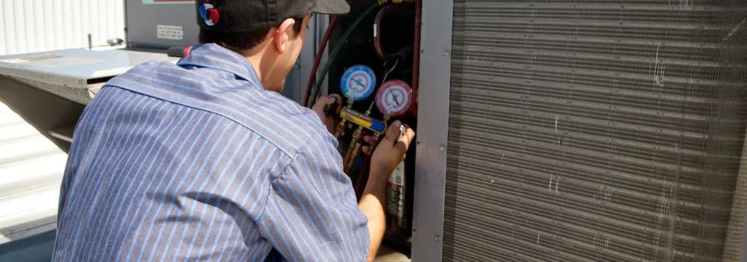 HVAC technician servicing a condenser unit in Davenport