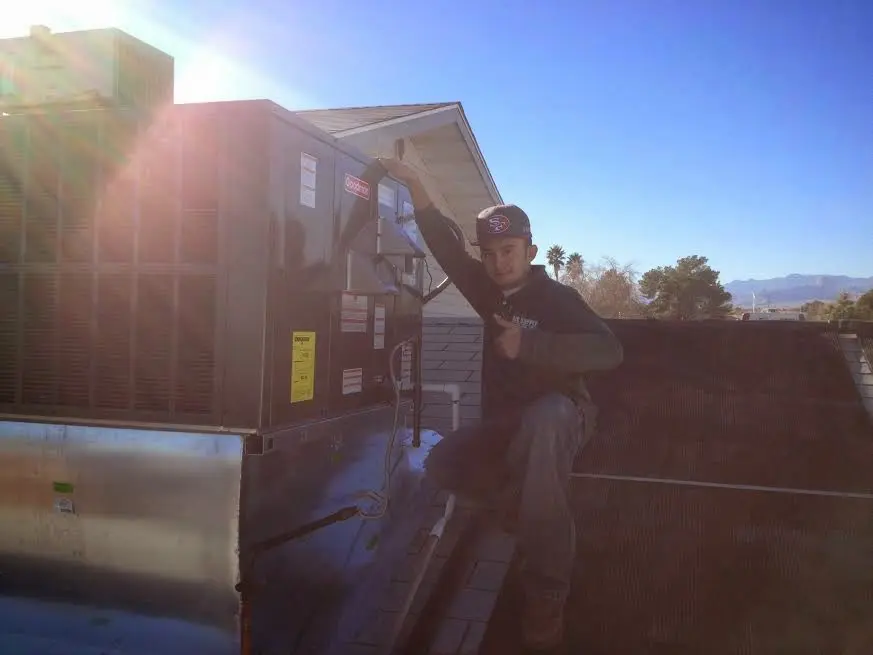 HVAC technician performing Heat Pump Repair on a rooftop unit in Davenport